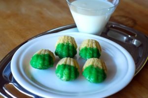 Madeleine Biscuits with green frosting on a white plate