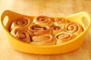 Baked cinnamon rolls in a yellow baking dish