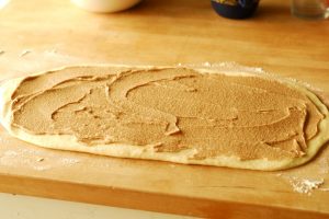 yeast cinnamon roll dough with cinnamon sugar mixture spread over the dough