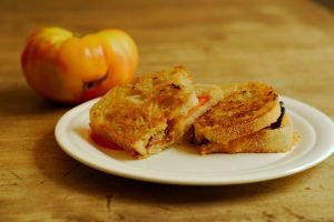 Heirloom Tomato Grilled Cheese from A Duck's Oven. Grilled cheese sandwiches made with heirloom tomatoes and bacon on crusty bread.