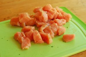 raw chicken on a green cutting board 