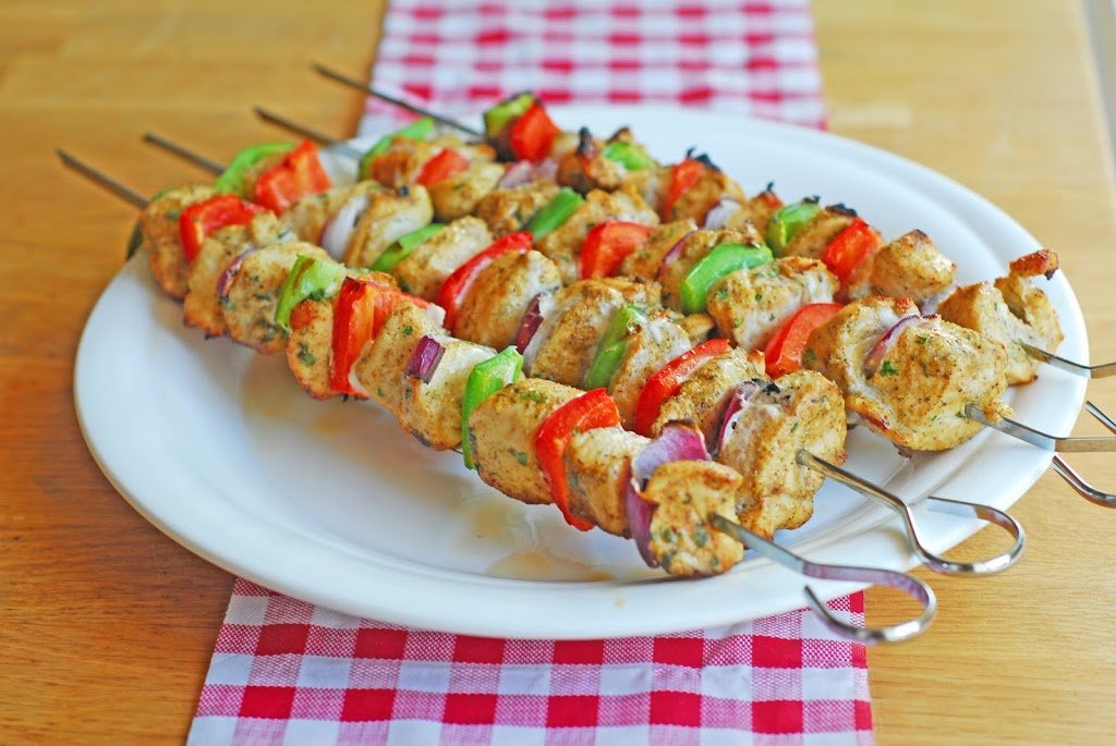 grilled chicken kebabs on a white plate