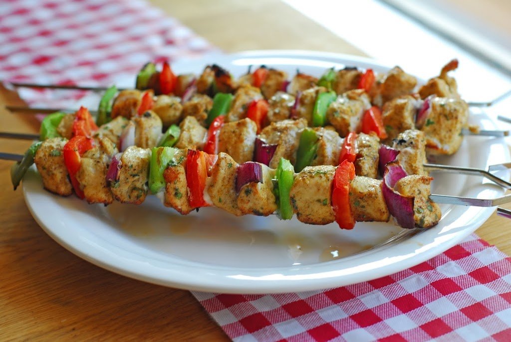 grilled chicken kebabs on a white plate