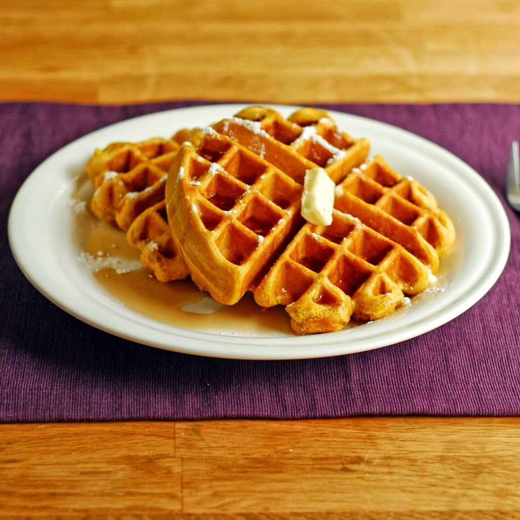 pumpkin waffles with butter and syrup on a white plate