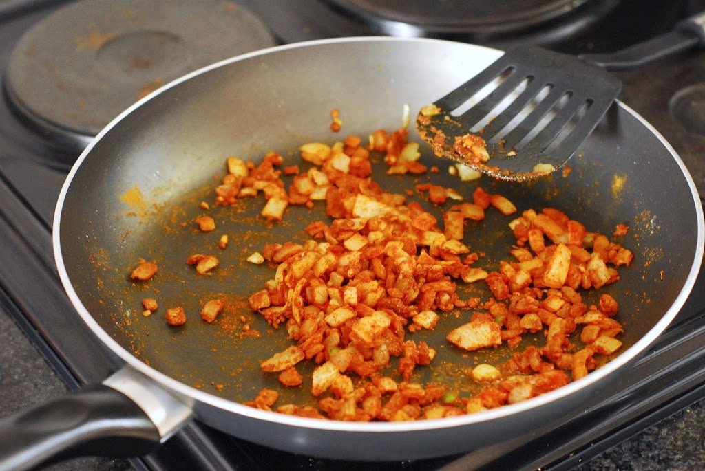 Onions and garlic with spices in saute pan.