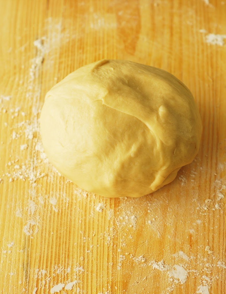 Boule de pâte sur planche à découper farinée