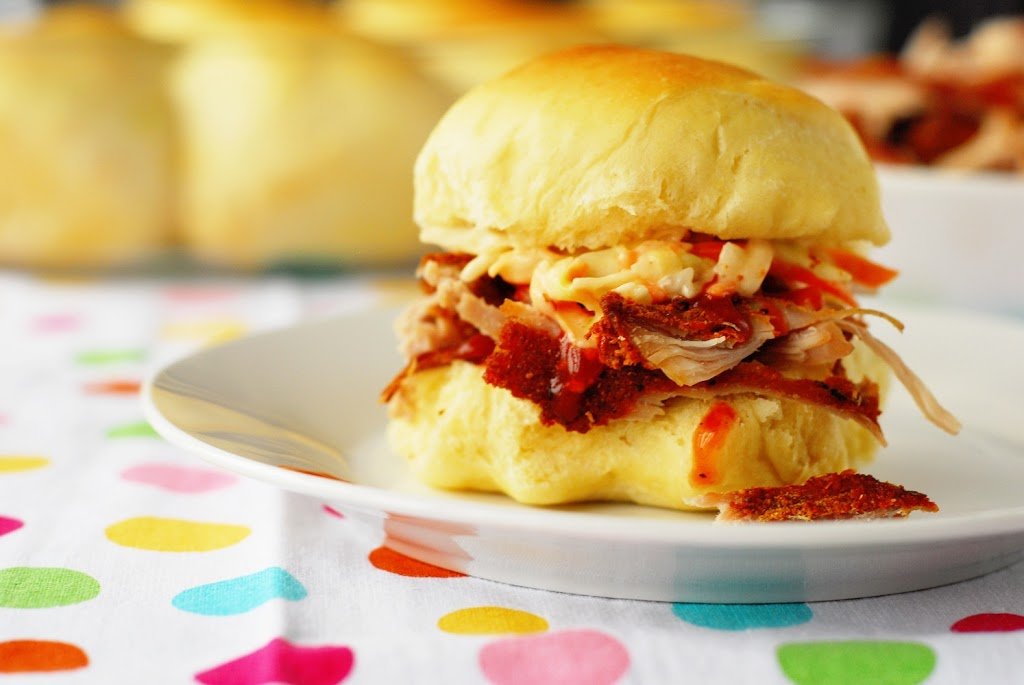 Pulled Pork Slider auf weißem Teller auf gepunktetem Handtuch