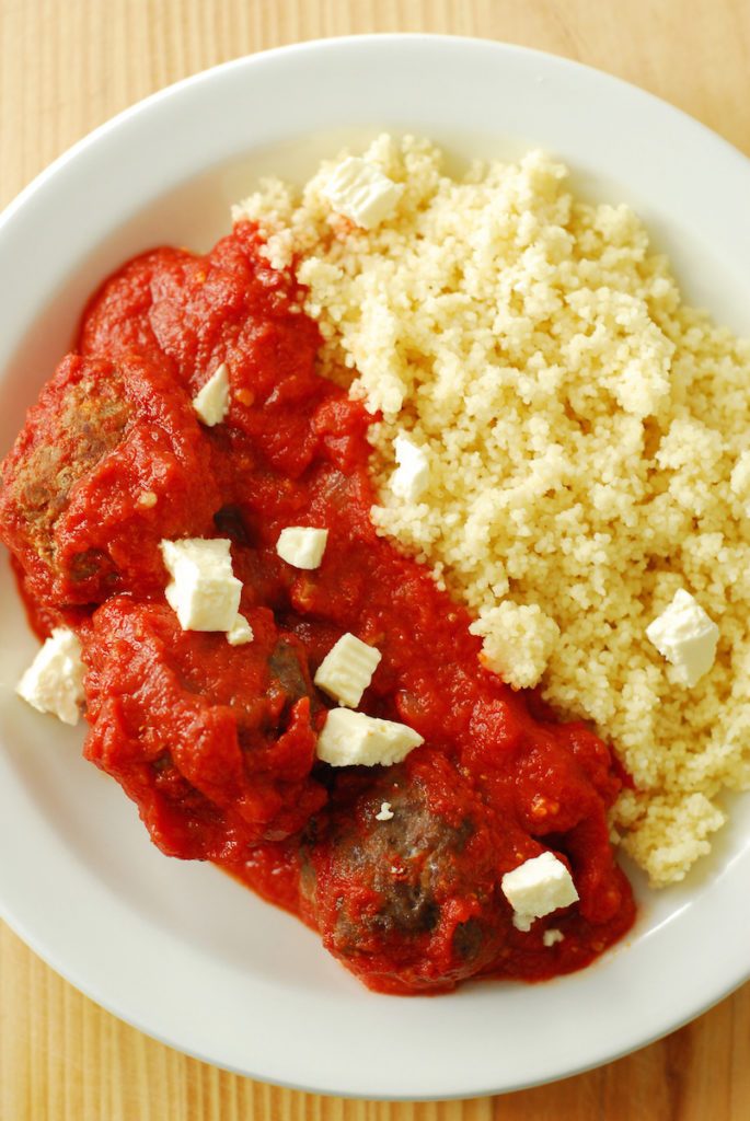 Ethiopian Meatballs and Couscous from A Duck's Oven. Meatballs cooked in a spicy, fragrant tomato sauce and served over couscous. Topped with feta cheese for a creamy kick!