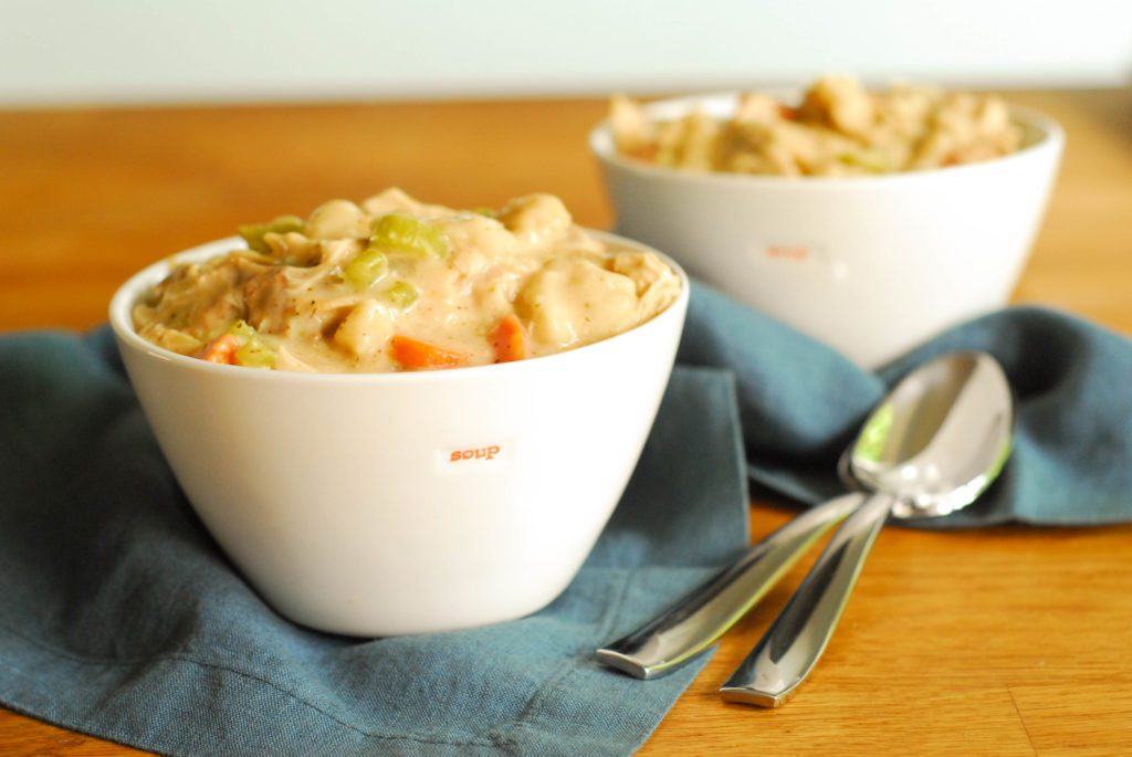 Bowls of chicken and dumplings soup on blue napkin