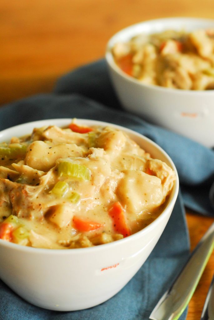 Bowls of chicken and dumplings soup on blue napkin