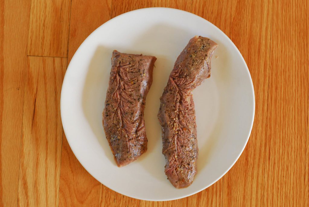  Gekochtes Sous-Vide-Steak auf weißem Teller auf Holzoberfläche