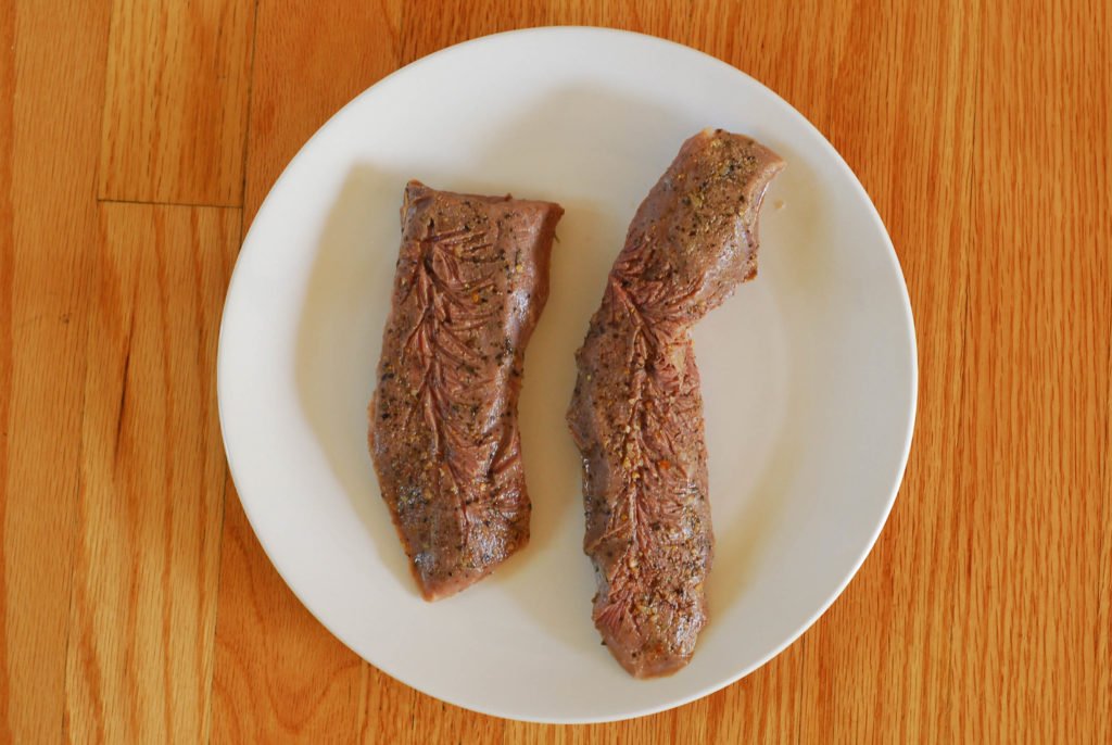 Vařené sous vide steak na bílém štítku na povrchu dřeva