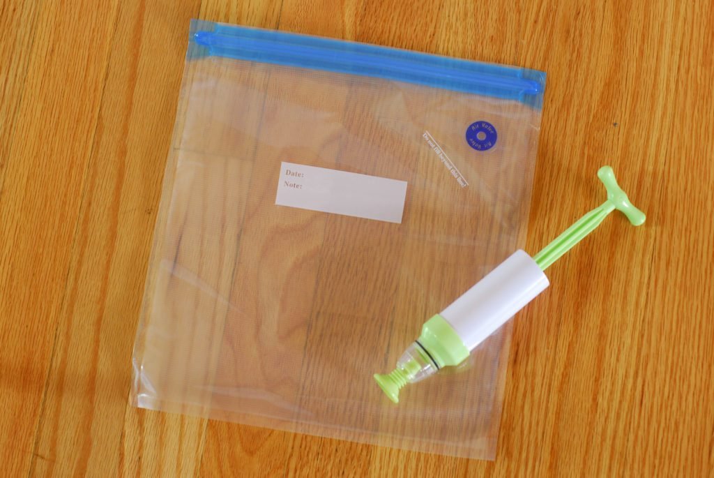 herbruikbare zak en pomp voor sous vide op een houten oppervlak