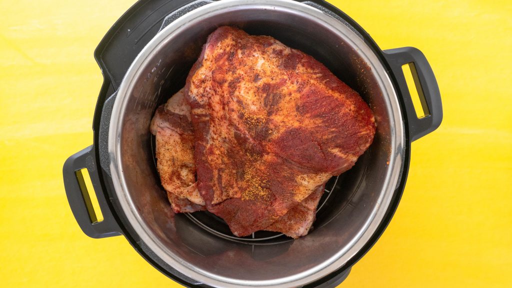 Rack of ribs in Instant Pot on yellow surface
