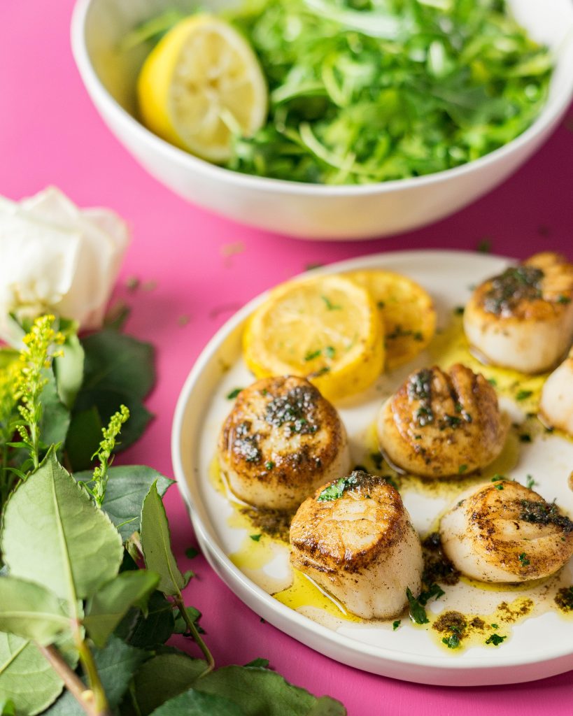 Sous Vide scallops and lemons on a white plate