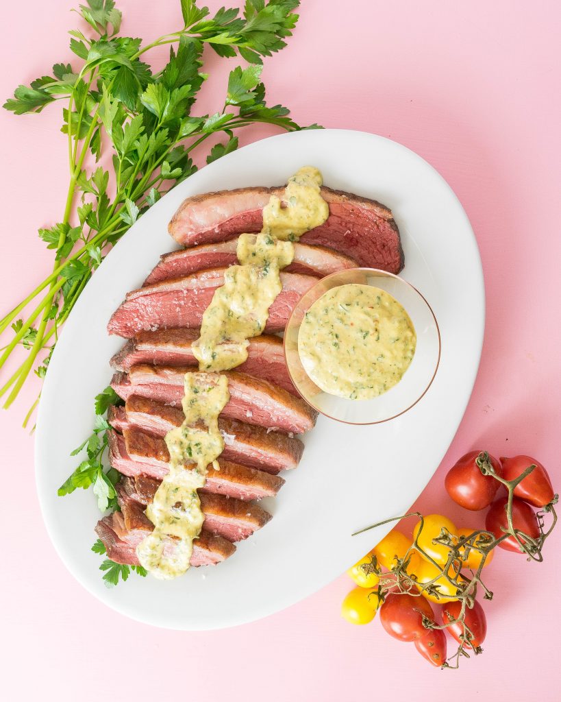 Sliced steak picanha steak with horseradish sauce over it 