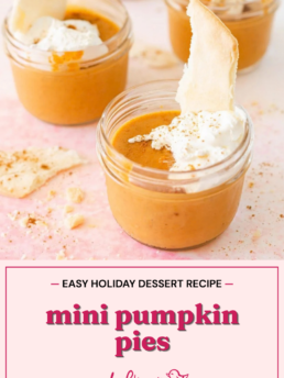 Small glass jars filled with sous vide pumpkin pie mousse, topped with whipped cream and a crust shard, with text reading Easy holiday dessert recipe: mini pumpkin pies.