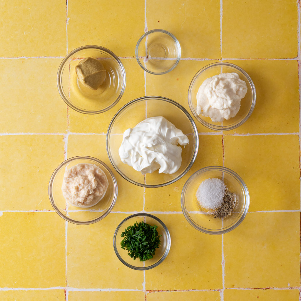 Ingredients for creamy horseradish sauce on yellow tile.