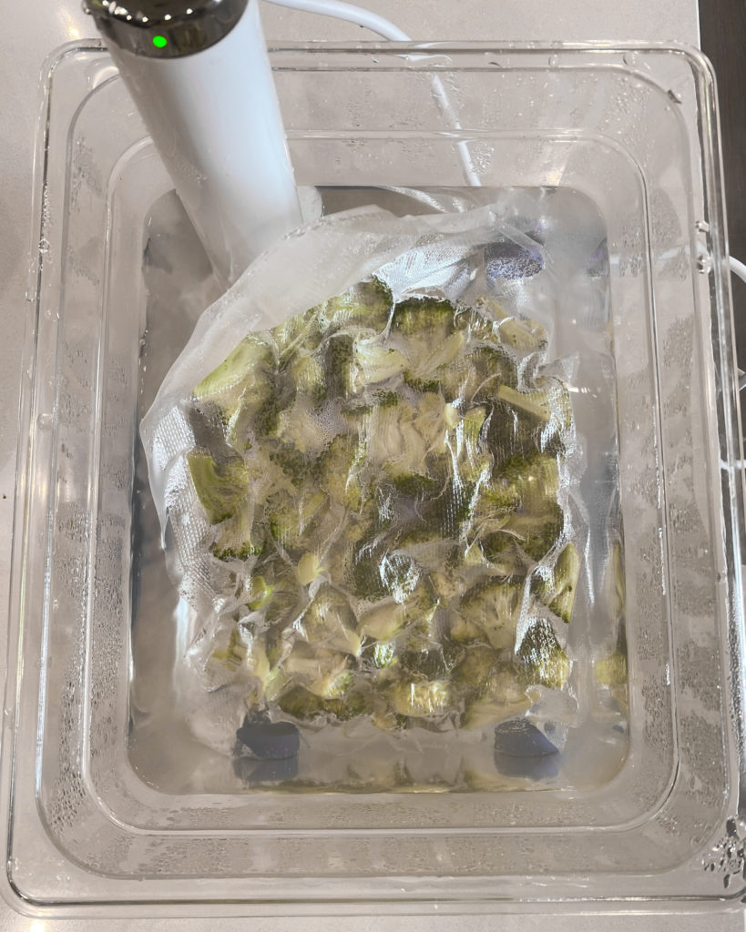 Vacuum sealed broccoli in sous vide water bath.