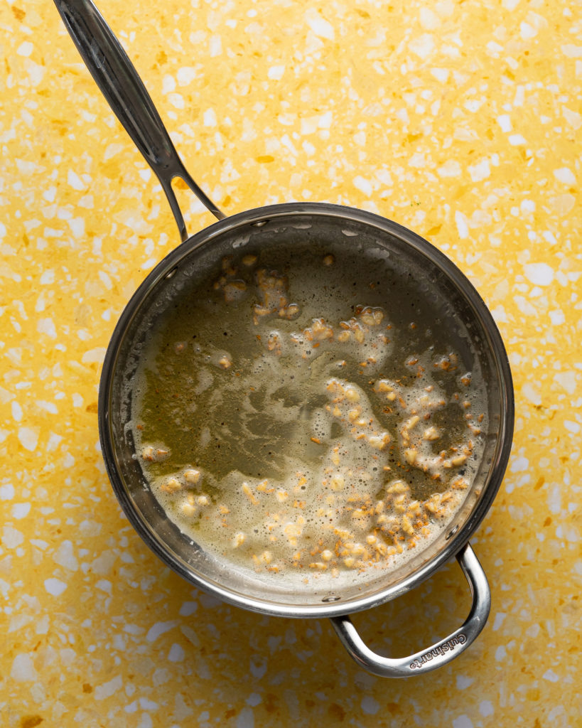Garlic butter sauce in stainless skillet.