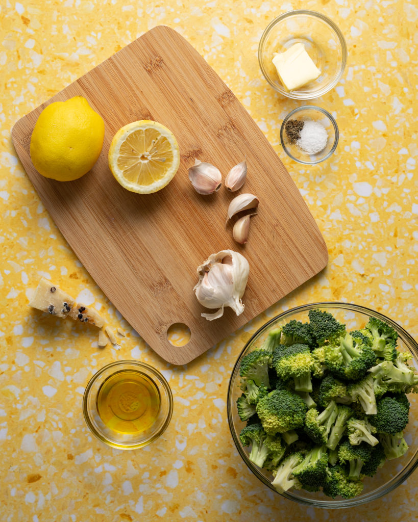 Ingredients for sous vide broccoli on yellow surface.