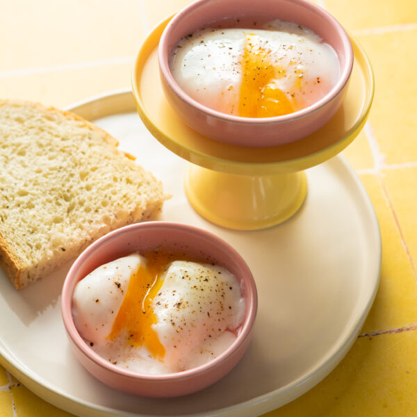 Sous vide poached eggs in pink dishes on plate with thick toast.