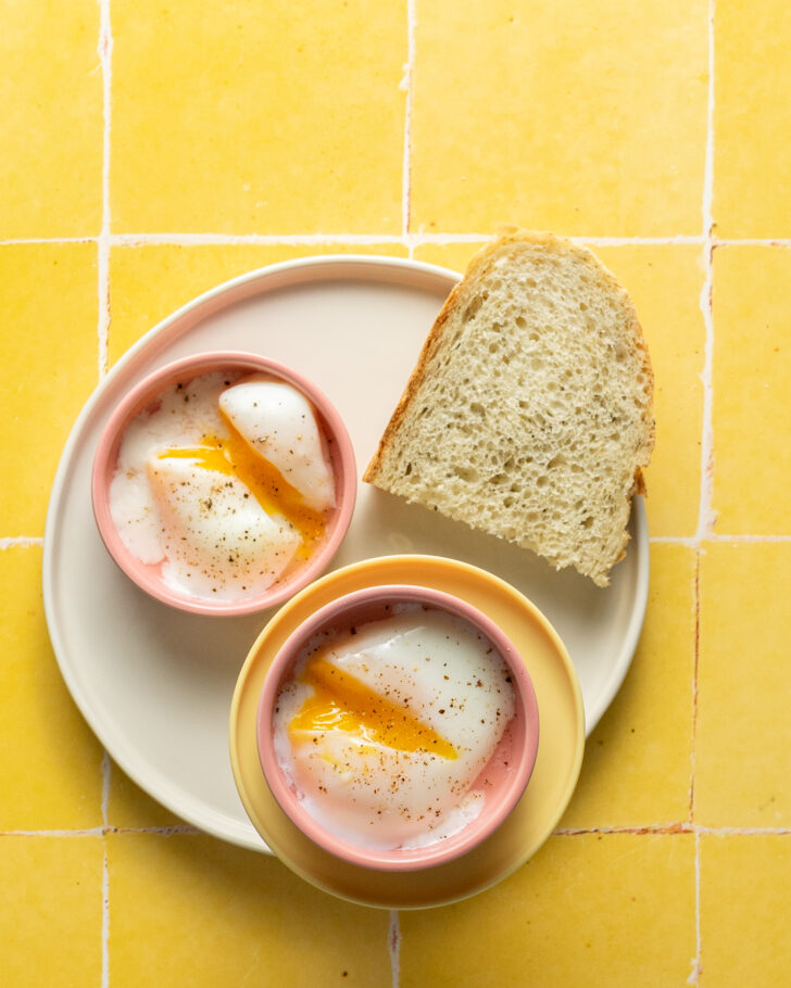Sous vide poached eggs in pink dishes on plate with thick toast.
