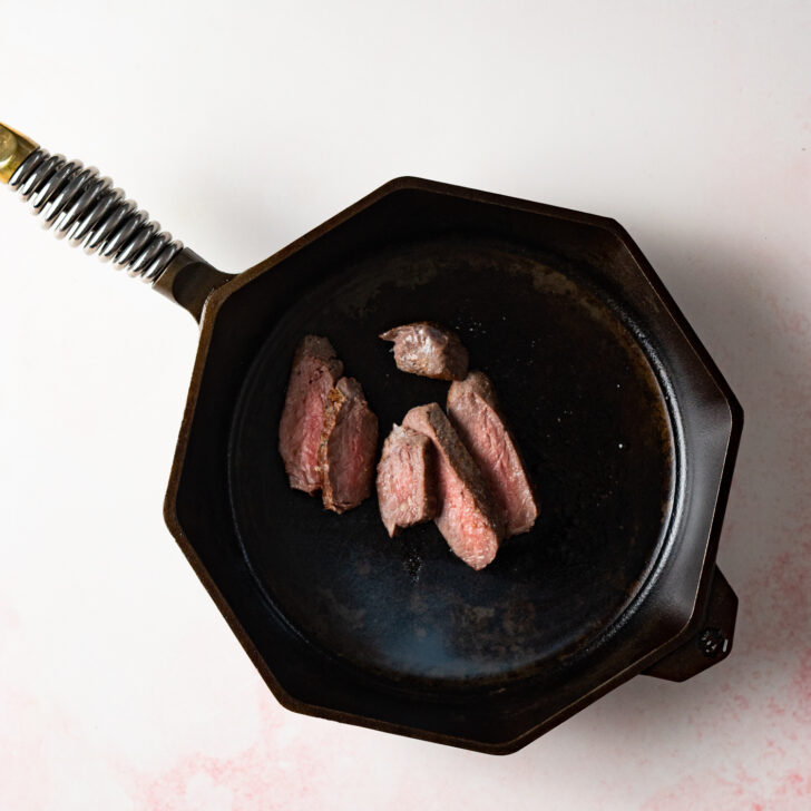 Sliced steak in cast iron skillet