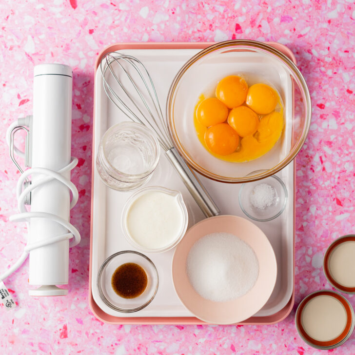 Ingredients and equipment needed for sous vide creme brulee on pink surface.