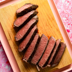 Sliced sous vide top round roast on a wood cutting board.