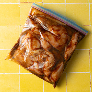 Chicken marinating in zipper top bag.